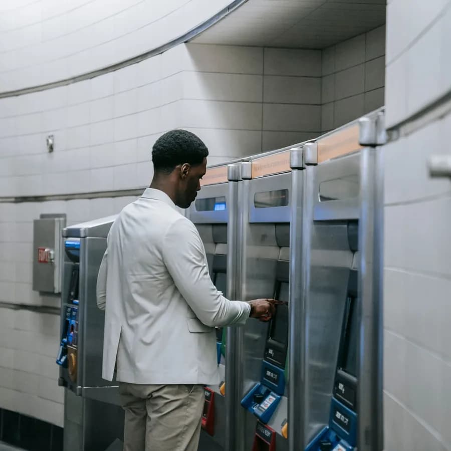 A bank customer withdrawing cash at a row of ATMs